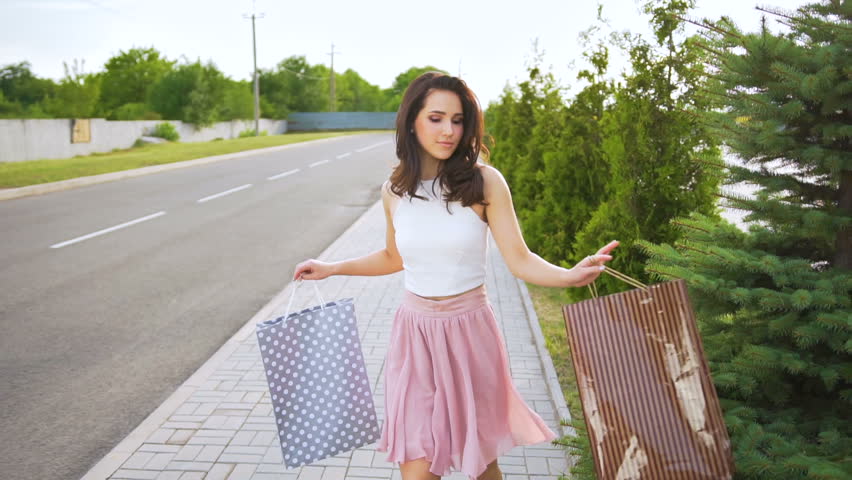 Young handsome woman is dancing after shopping holding shopping bags near mall Royalty-Free Stock Footage #29272870