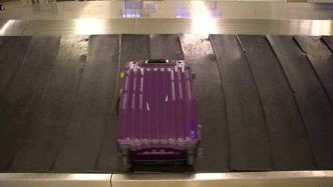 4k Baggage Claim in international airport. People picking up suitcase and Bags from conveyor belt at Taiwan. Luggage travels on a conveyor belt-Dan