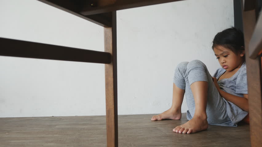 Asian children sitting on the floor of living room ,She like to looking cartoons movies by smart phone , video for family and education concept