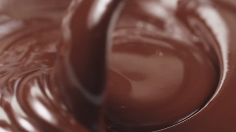 Slow motion stirring premium dark melted chocolate with big spoon