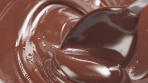 Slow motion stirring premium milk melted chocolate with big spoon