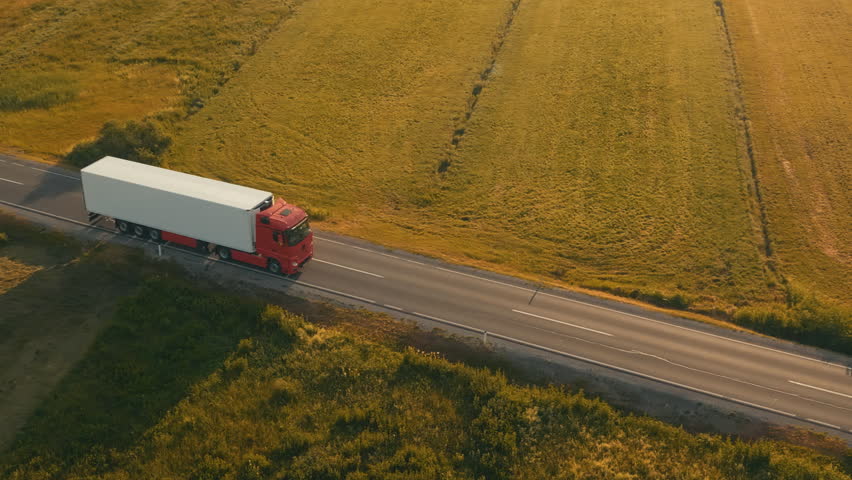 Aerial side shot of a truck on the road in beautiful countryside in the sunset light. Royalty-Free Stock Footage #29292949