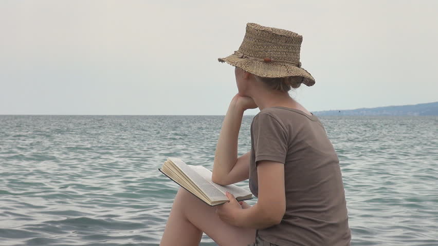 Beautiful woman reading on the beach
