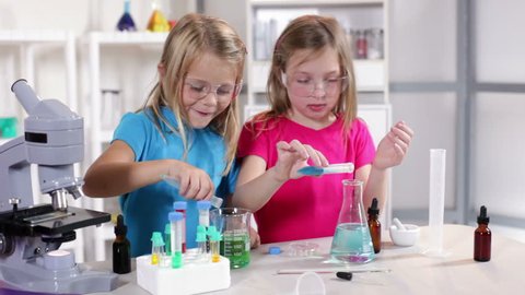 Little girls enjoy working with different liquid while learning about chemistry.