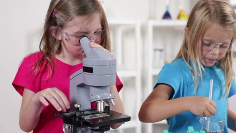 Little girls enjoy working with different liquid while learning about chemistry.