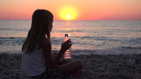 Child Watching Sea Waves Drinking Water at Sunset, Thirsty Girl on Seashore 4K