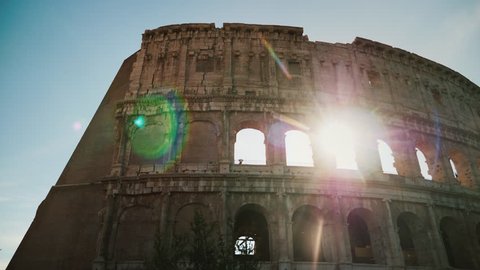 Arch of the famous Colosseum in Rome. The sun's rays shine through them. Steadicam shot