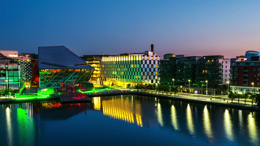 Dublin, Ireland. Aerial view of Grand Canal docks in Dublin, Ireland at sunrise. Empty streets and illuminated modern buildings, colorful clear sky. Time-lapse from night to day. Zoom in Royalty-Free Stock Footage #29300434