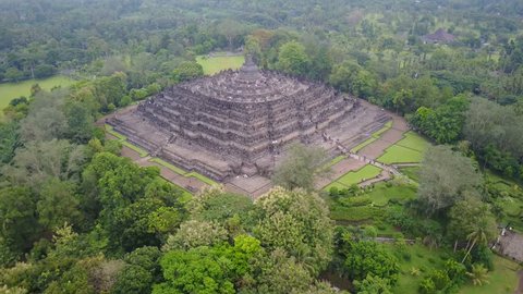 BOROBUDUR, INDONESIA - APRIL 2017: Tilting drone shot of beautiful Borobudur Buddhist temple complex, history and culture in Indonesia