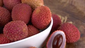 Lychees rotating on a wooden plate as seamless loopable 4K UHD footage