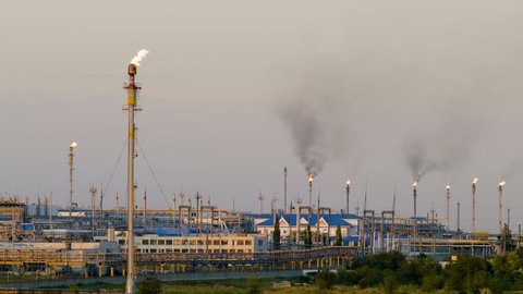 Huge gas and oil processing plant with burning torches, pipes and distillation of the complex