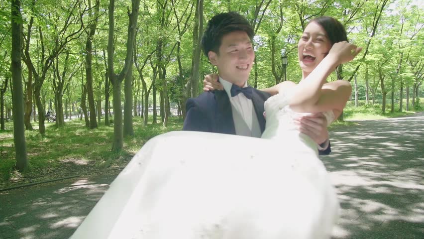 Japanese groom spinning beautiful new bride  stylized color grade  