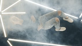 A female dancer lying down on the dance floor begins to move leisurely while remaining supine and as smoke fills the room. - Powered by Shutterstock - Get 15% off with code: PIKWIZARD15