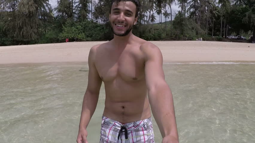 Handsome Latin Man Walk On Beach Holding Hand Talking Action Camera POV Of Young Couple On Seaside During Summer Vacation