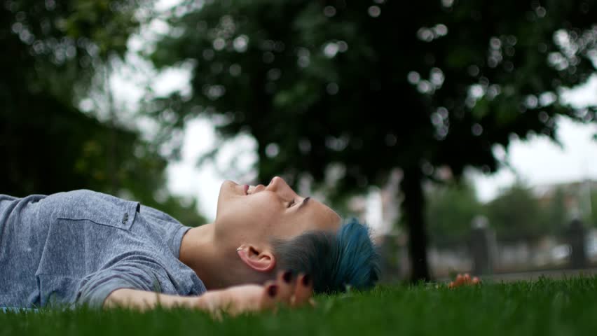 The girl is lying on the grass and the guy is kissing her. A loving couple on the grass. Man and woman are a romantic moment.