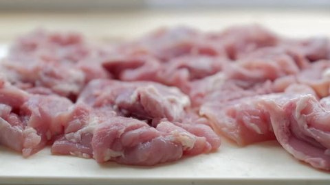 Raw chicken meat on a white board