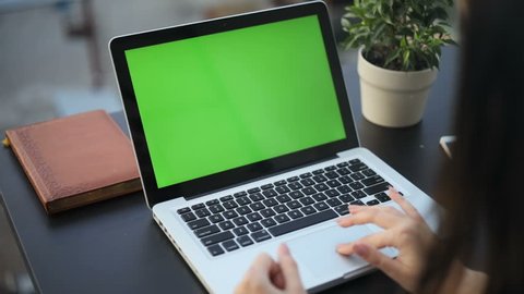 Closeup woman sitting table notebook female hands keyboarding laptop using texting pointing networking green screen chroma key chromakey keyboard white device working message student businesswoman