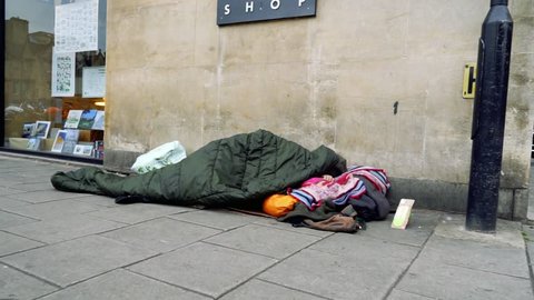 Poor socially excluded disadvantaged person sleeping on the pavement sidewalk in a street in Oxford England