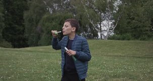 Young boy boy blows a bubbles in the garden, in Ultra HD video 4k (4096x2160)