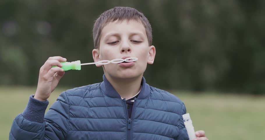 young boy blows bubbles garden ultra: стоковое видео (без лицензионных плат...