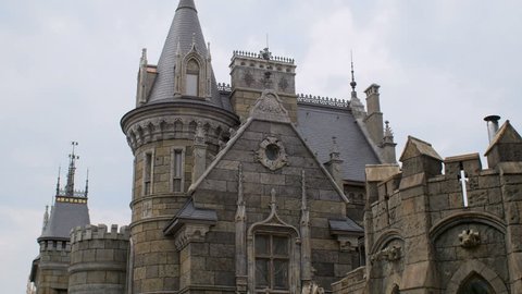 facade of medieval castle, builded by stone bricks, sky and clouds are in background
