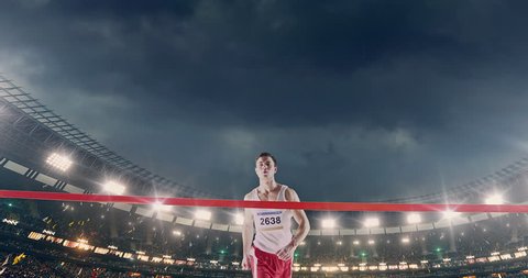 Male track and field runner crosses finishing line on the professional sports arena. The man is happy, smiling with his arms raised. Arena and people on it are made in 3D and animated.