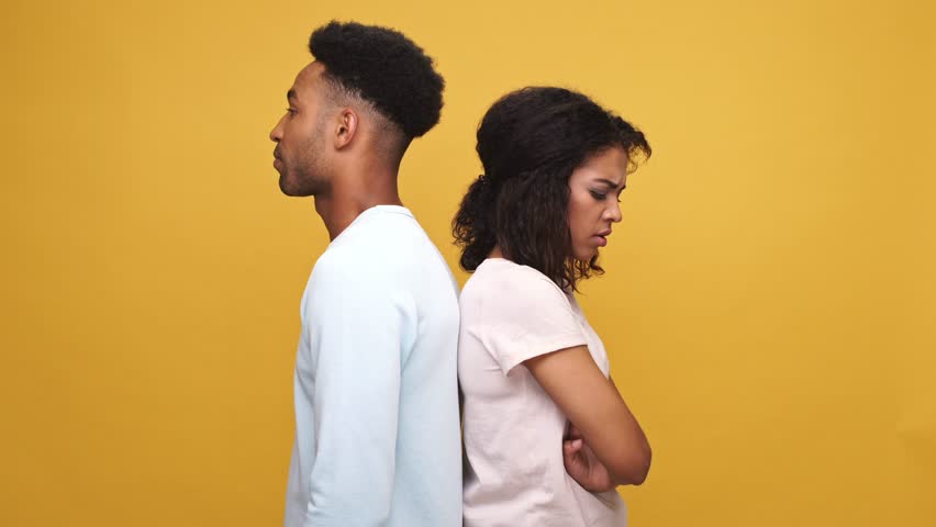 Young afro american man trying to make up a quarrel with his offended girlfriend isolated over yellow background | Shutterstock HD Video #29353459