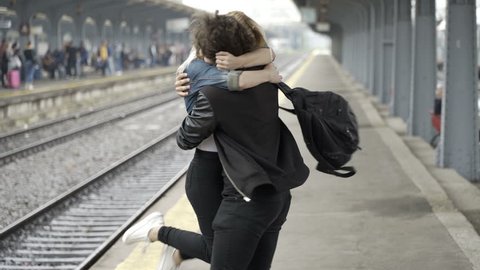 Cute blonde girl looking for boyfriend then kissing him and showing her love in train station