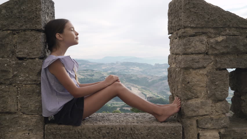 Little girl child relax on the background of the mountains. San Marino, Italy