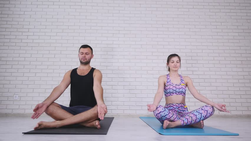 Couple doing yoga in studio.