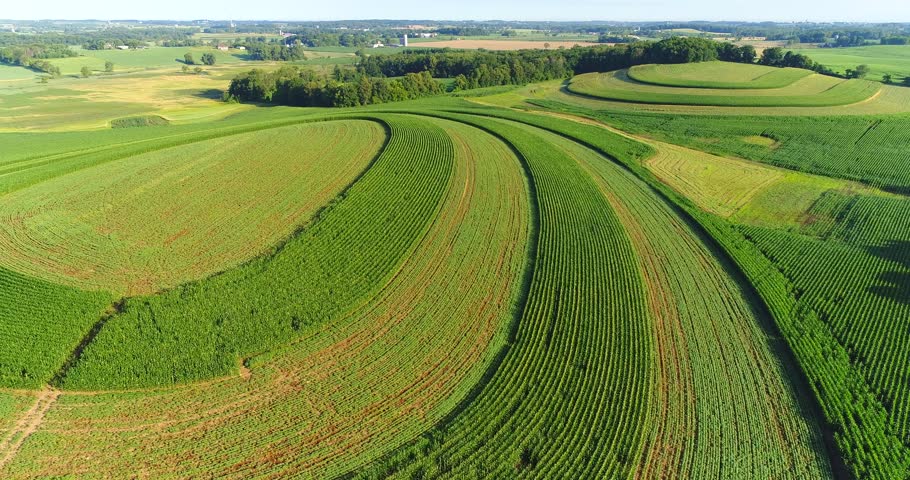Stunning striped green fields over rolling hills, rural Wisconsin in Summertime, aerial view.