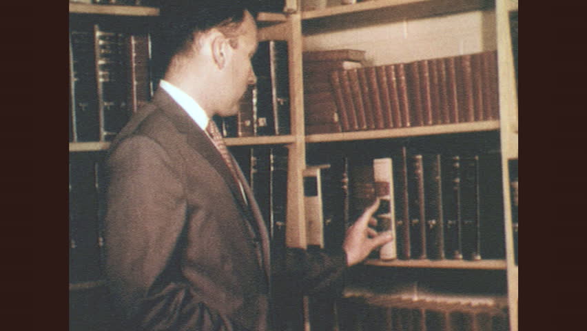 1950s: Man looks at book on shelf. Building with garden. Man graduating | Shutterstock HD Video #29370646