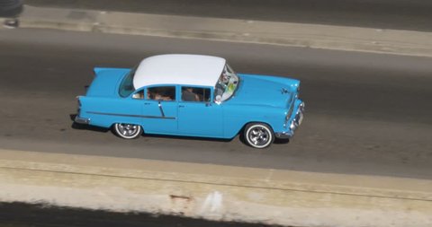 A high angle aerial view of colorful classic cars traveling on the streets of Havana, Cuba.  	