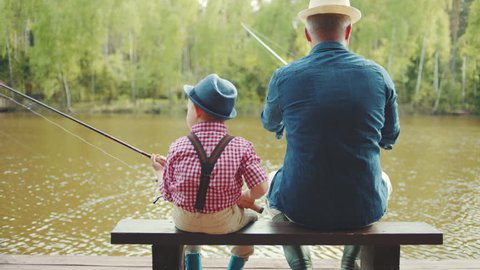 Grandfather and his grandson are casting lines during salmon fishing on the river