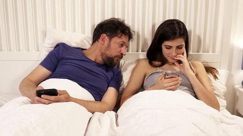 Man trying to look at cell phone of girlfriend while she is chatting, scared of cheating. medium shot