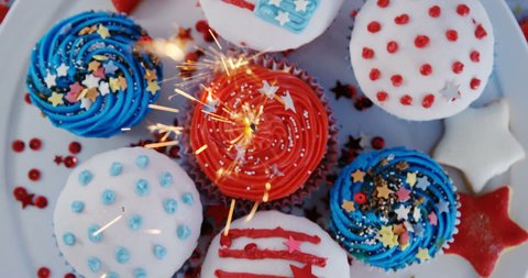 Burning sparkler on decorated cupcakes with 4th july theme Stock Video