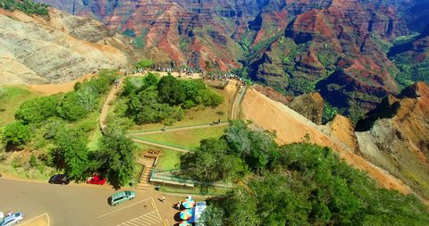 Tourist Crowd Overlooking Tropical Mountain Valley with Red and Green Banded Cliffs - Aerial Footage from Kauai, Hawaii