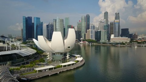SINGAPORE - MAY 2017: Aerial drone shot flying over Lotus flower building of science museum towards modern skyline financial and business district at Marina Bay in Singapore