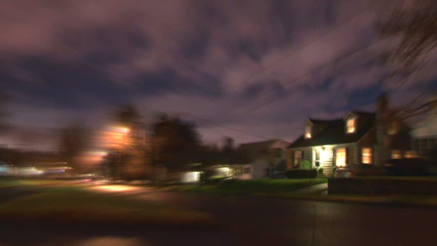 Night time lapse in residential neighborhood with person running in super speed effect.