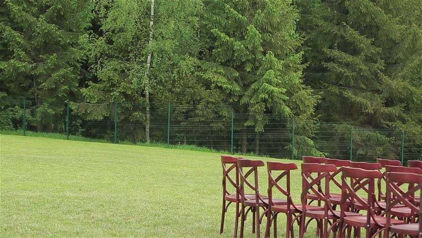 Rows of chairs at a wedding ceremony. Wedding Flower Arch Decoration. Wedding arch decorated with flowers. Outdoor