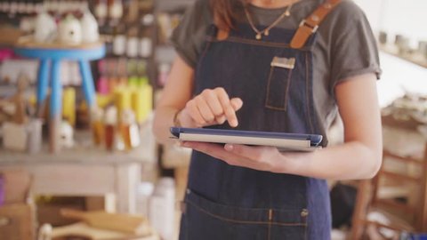 Midsection Of Small Business Owner Using Digital Tablet In Delicatessen