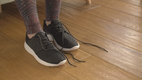 Fit Woman Tying Laces Of Sport Shoes On Hardwood Floor