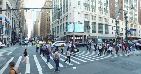 New York City, Circa 2017: High angle view overhead Manhattan intersection crosswalk and traffic during morning rush hour commute. Crane dolly shot rise above street level