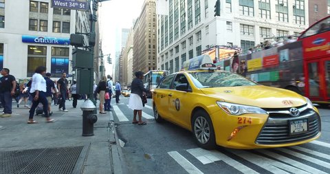 New York City, Circa 2017: Manhattan commuters hail yellow taxi cab during busy morning rush hour. Dolly crane high angle 4K shot. Motion stabilized video