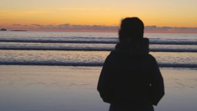 Silhouette Woman Looking At Serene Waves During Sunset