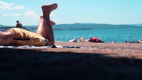 a Man is Sunning on the Beach Near the Ligurian Sea. Recreation. - Powered by Shutterstock - Get 15% off with code: PIKWIZARD15