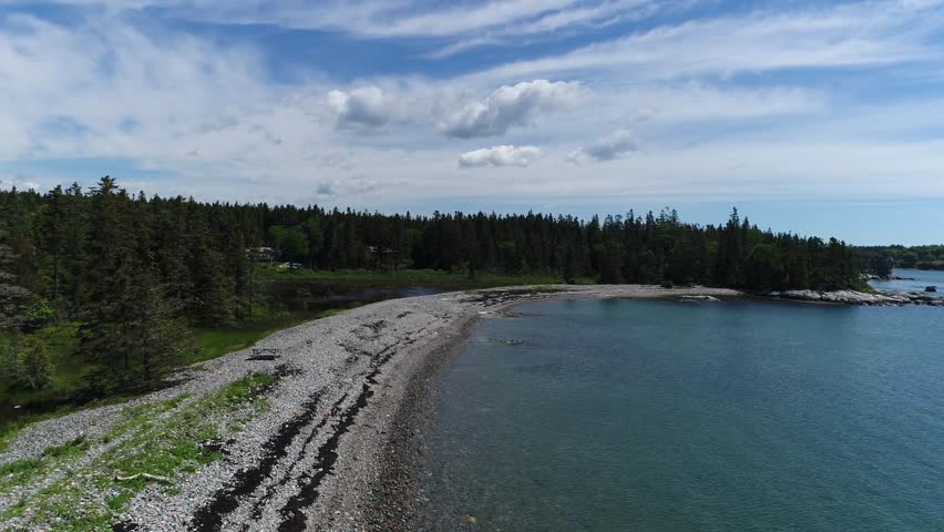 A moving aerial view along the Bernard shoreline within Bass Harbor on Mt Desert Island Maine