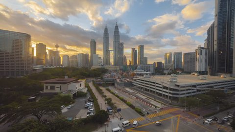 Time lapse: Kuala Lumpur during a dramatic dusk overlooking the city skyline and a busy intersection with light trails. 