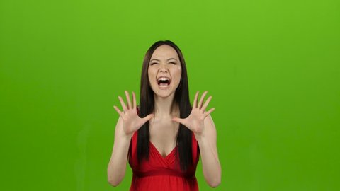 Asian girl is indignant with people, she is angry. Green screen
