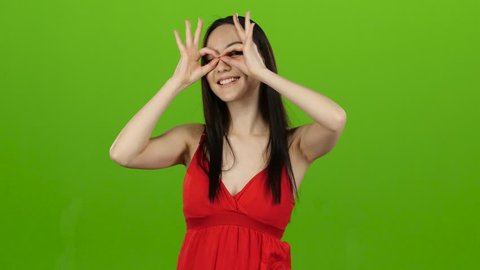 Girl of asian appearance has fun and makes different grimaces. Green screen